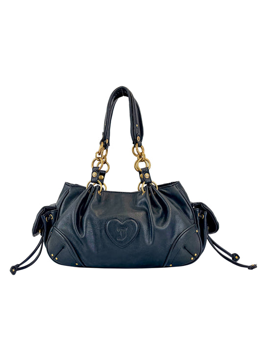 The Vintage Vibes Satchel Bag is a black leather bag featuring gold chain-accented handles, heart-shaped front stitching, side drawstrings, and gold-tone studs at the corners for a chic retro look.