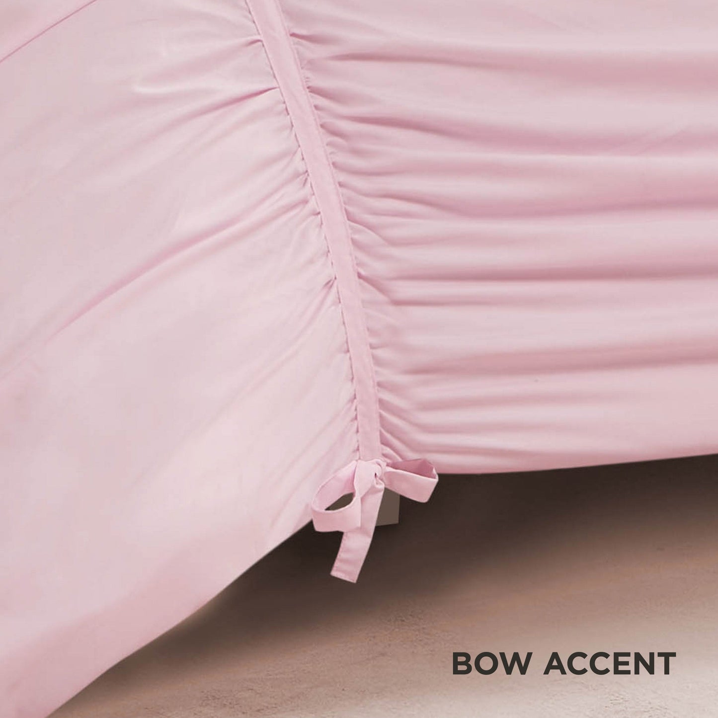 A close-up of the Ribbon Ruched Comforter Set in light pink highlights its ruched seams and a small matching bow, with elegant ribbon detailing. The words BOW ACCENT appear in black text at the bottom right.