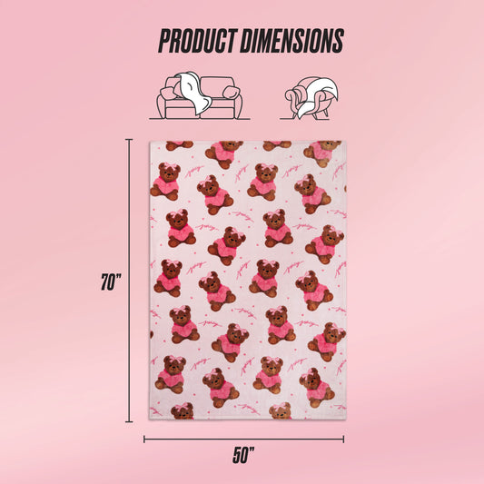 A rectangular pink Kids Plush Throw Blanket with a teddy bear pattern is shown, measuring 70 x 50 inches. Icons highlight its ultra-soft use for couch or bed, with Product Dimensions text also included.