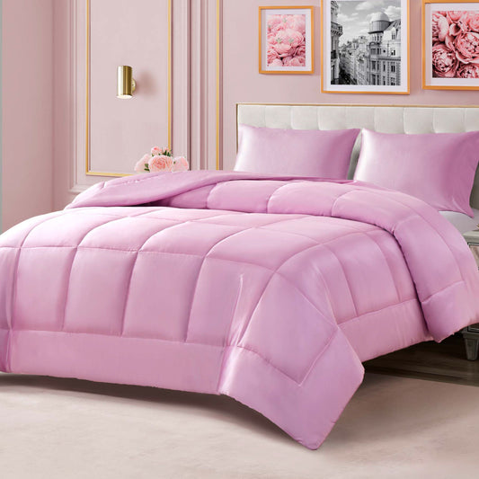 A neatly made bed features the Solid Satin Down Alternative Comforter in soft pink, providing all-season warmth, with matching pillows in an elegant bedroom adorned with pink flowers and framed art on the wall.