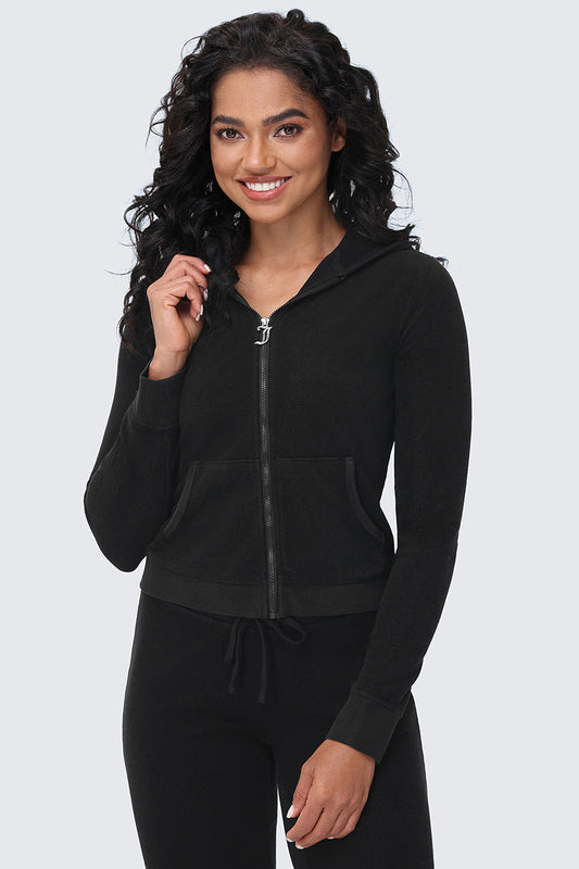 A woman with long curly hair wears the Big Bling Washed Terry Hoodie with front pockets and matching black pants, smiling while standing against a light gray background.