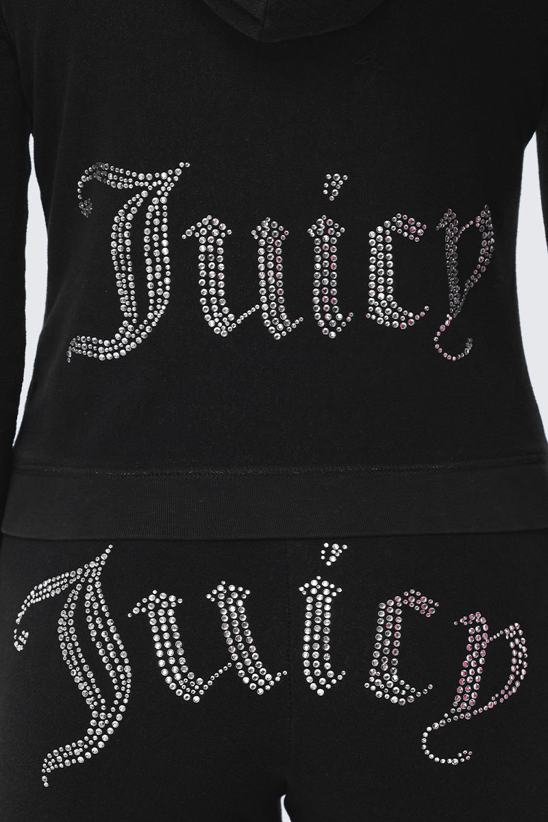 Someone dressed in the Big Bling Washed Terry Hoodie, a black terry hoodie with "Juicy" spelled out in rhinestones on the back, along with matching pants featuring the same sparkling design.