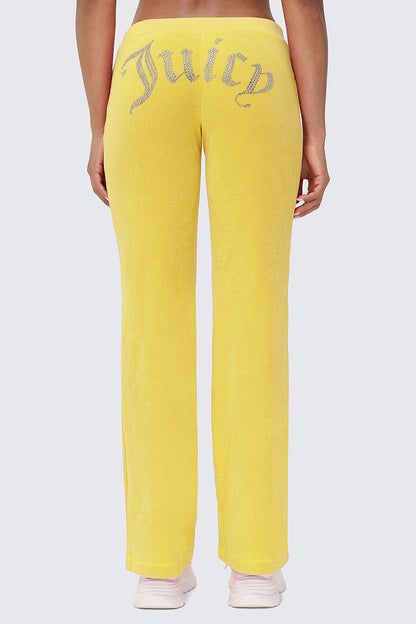 Someone wearing bright yellow Big Bling Washed Terry Track Pants, featuring rhinestone detailing across the back, stands with their back to the camera.
