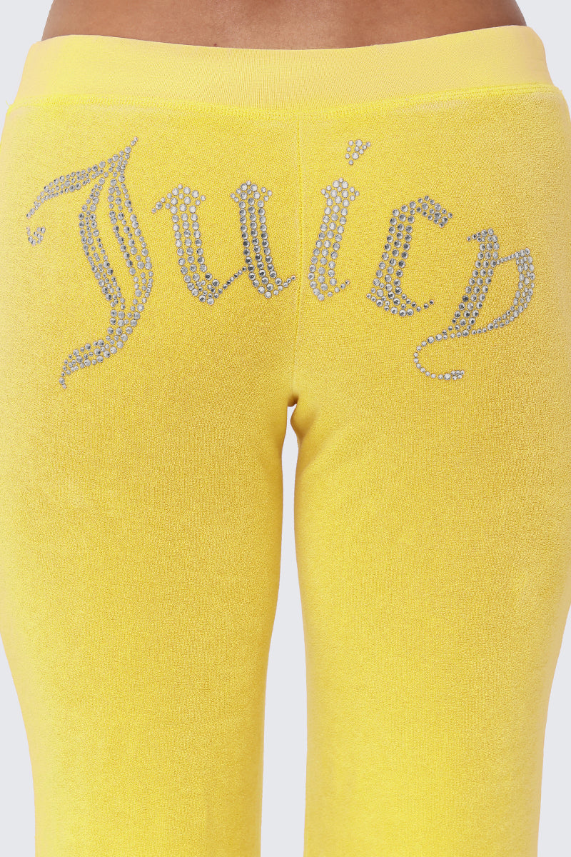 Close-up of the back of Big Bling Washed Terry Track Pants in yellow, featuring the Juicy logo spelled out in rhinestones across the upper part.