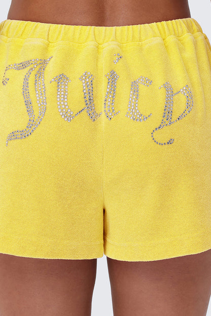 A close-up of a person wearing Big Bling Washed Terry Shorts, vintage-inspired yellow velour with a rhinestone Juicy logo across the back.