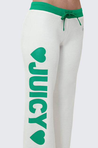 A person wears Contrast Low Rise Track Pants: white sweatpants with green trim, a green drawstring, and "JUICY" with two green hearts printed vertically on the left leg.