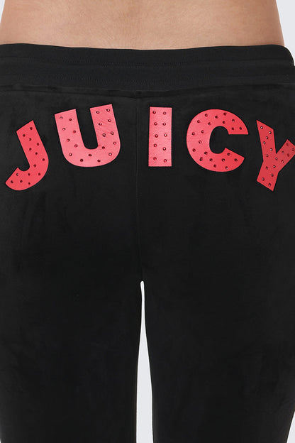 Close-up of the back of the Cherry Bling Velour Jogger, featuring a bold Juicy graphic in large red letters, accented with small studs along the waistband and upper hips.