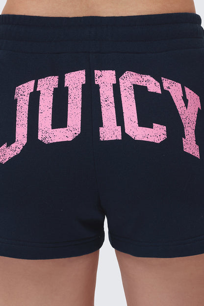 A close-up of the back of Collegiate Booty Shorts, dark terry with a drawstring waist and “JUICY” in large, distressed pink letters across the fabric.