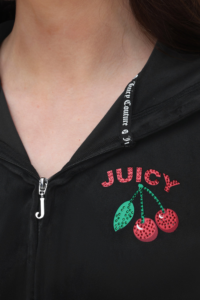Close-up of the Cherry Bling Velour Hoodie featuring pink rhinestone "JUICY" above a cherry graphic with green leaves on velour fabric; J-shaped zipper pull; short sleeves.
