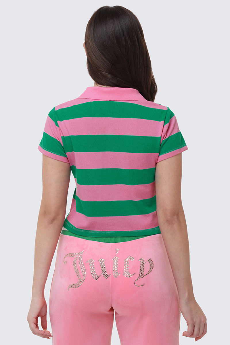 A person facing away wears the Stripe Embroidered Baby Polo with bold pink and green stripes, paired with light pink velour pants featuring "Juicy" in rhinestones across the back.