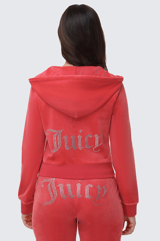 A person with long brown hair is shown from behind wearing the OG Big Bling Velour Hoodie in pink, featuring silver rhinestone Juicy embellishment on the back of both the hoodie and pants.