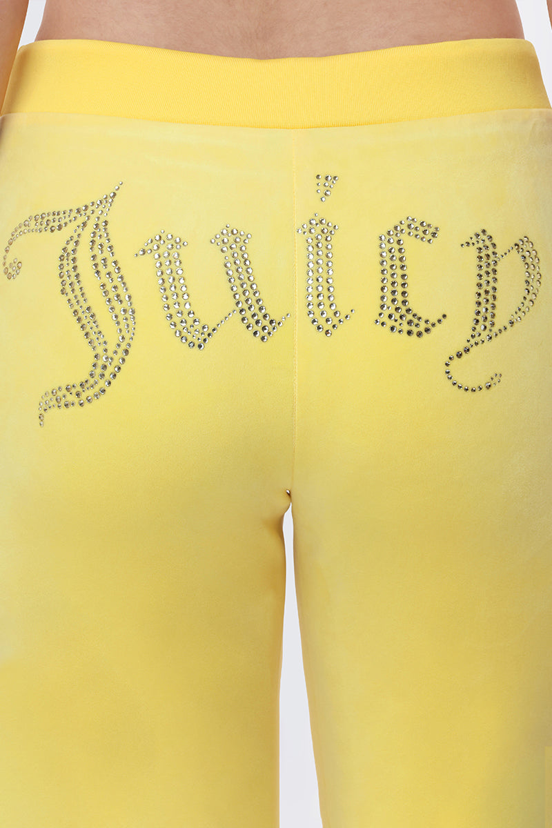 Close-up of OG Big Bling Velour Track Pants in Y2K-inspired yellow, featuring "Juicy" spelled out in rhinestones across the back.