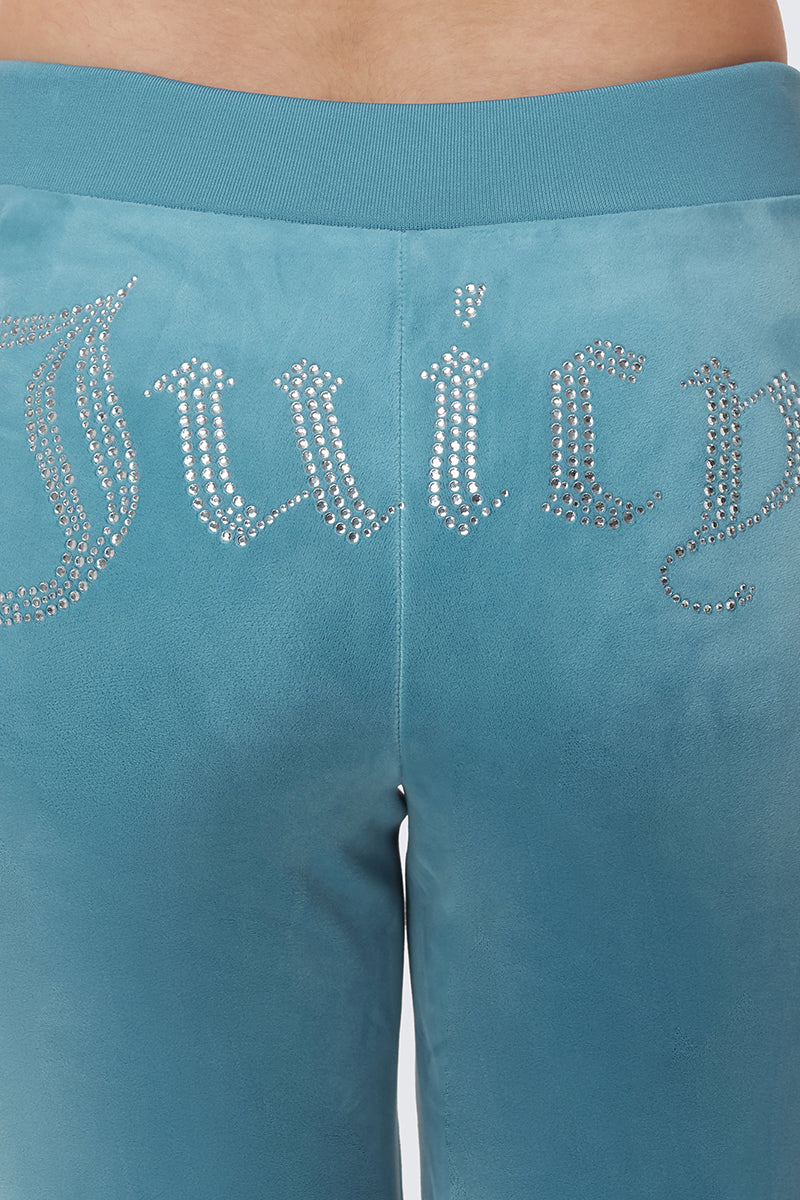Close-up of the back of OG Big Bling Velour Track Pants in teal, featuring "Juicy" spelled out in silver rhinestones across the waistband for a luxe Y2K vibe.