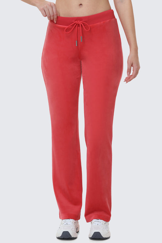Wearing OG Big Bling Velour Track Pants in bright red with white sneakers, only the lower half is visible against a plain light background—serving major Y2K vibes.
