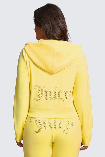 A woman seen from behind wears the Plus-Size OG Big Bling Velour Hoodie in bright yellow, featuring Juicy rhinestone embellishments on the back of the jacket and seat of the pants.