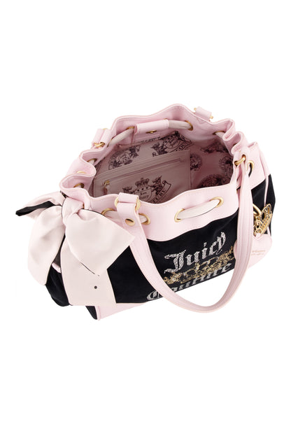 The Royal Bloom Daydreamer Tote Bag is black and pink with gold accents, a large side bow, open top showing a pink crown-and-crest interior, dual handles, and a drawstring closure for style and spaciousness.
