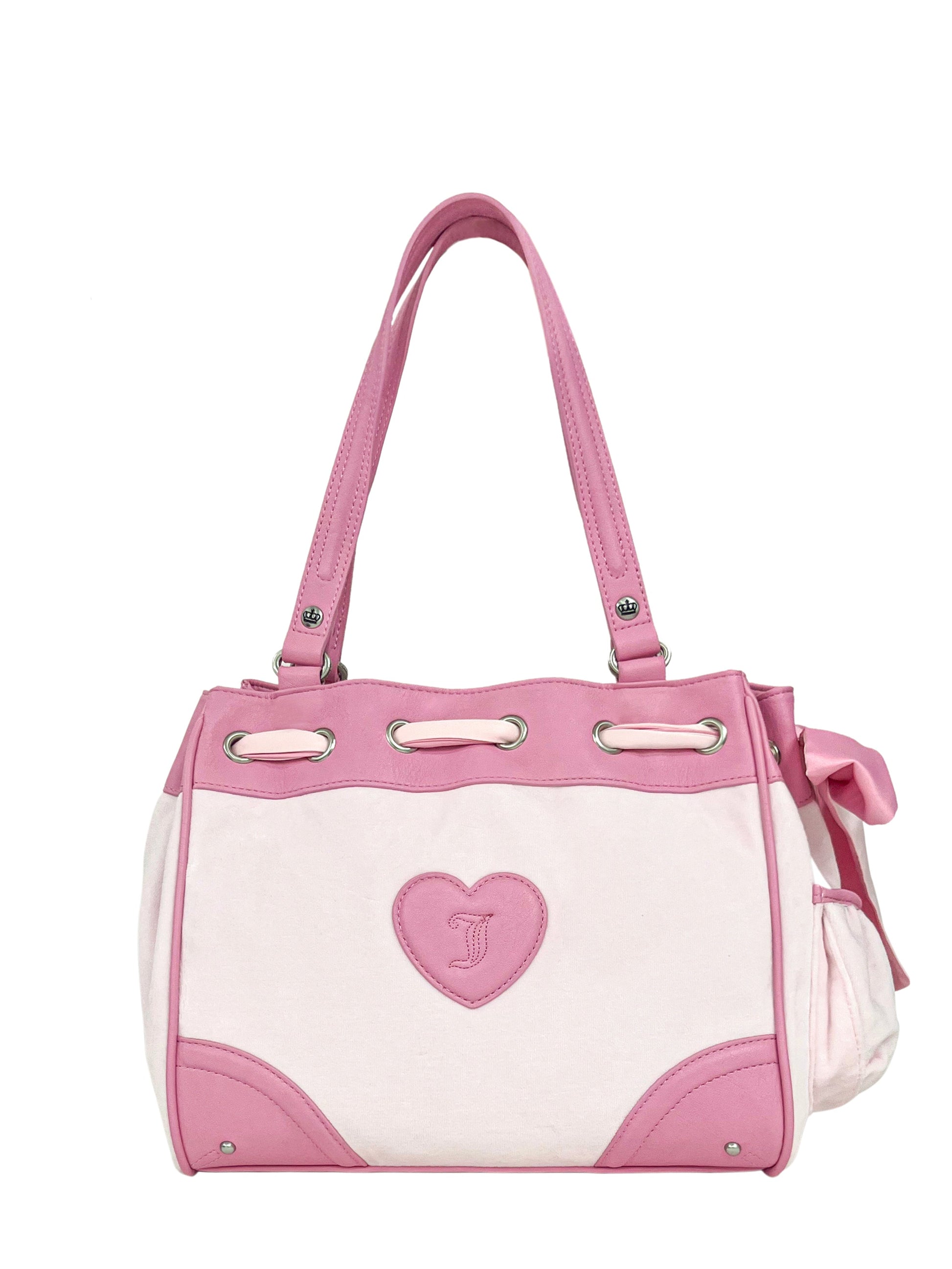 The Royal Bloom Daydreamer Tote Bag features light pink handles, trim, and accents, a heart-shaped emblem, and a pink bow. This off-white Juicy handbag adds chic elegance to any outfit.