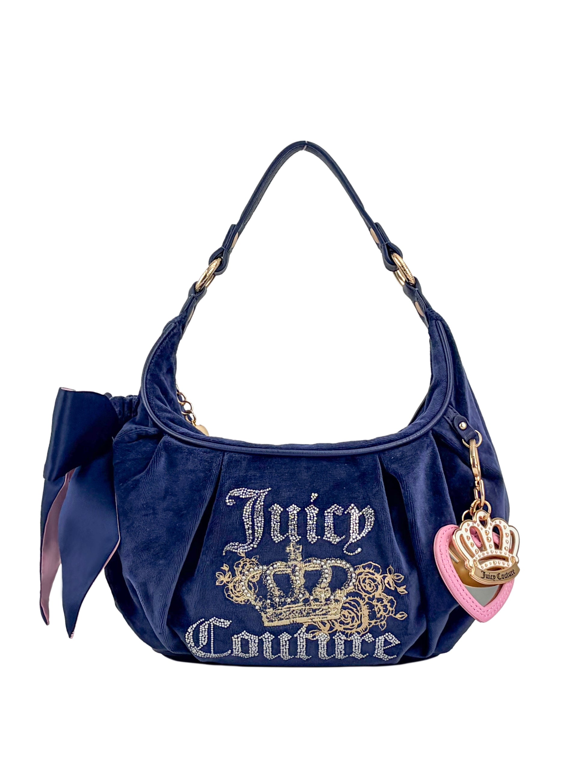 The Royal Bloom Hobo Bag by Juicy Couture features navy blue glam, a gold embroidered logo with crown, side bow, and a handle charm with gold crown and pink heart—ideal for fans of feminine handbags.
