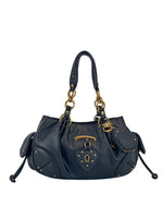 The Vintage Vibes Satchel Bag features black leather, gold hardware, double handles, and a decorative lock and key. Side pockets, studs, and a structured design add a throwback glamour to this Juicy satchel.