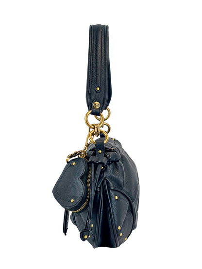 The Vintage Vibes Hobo Bag is a black leather handbag with gold studs, hardware, a thick handle, and a heart-shaped leather charm on a keyring, shown from the side against a white background.