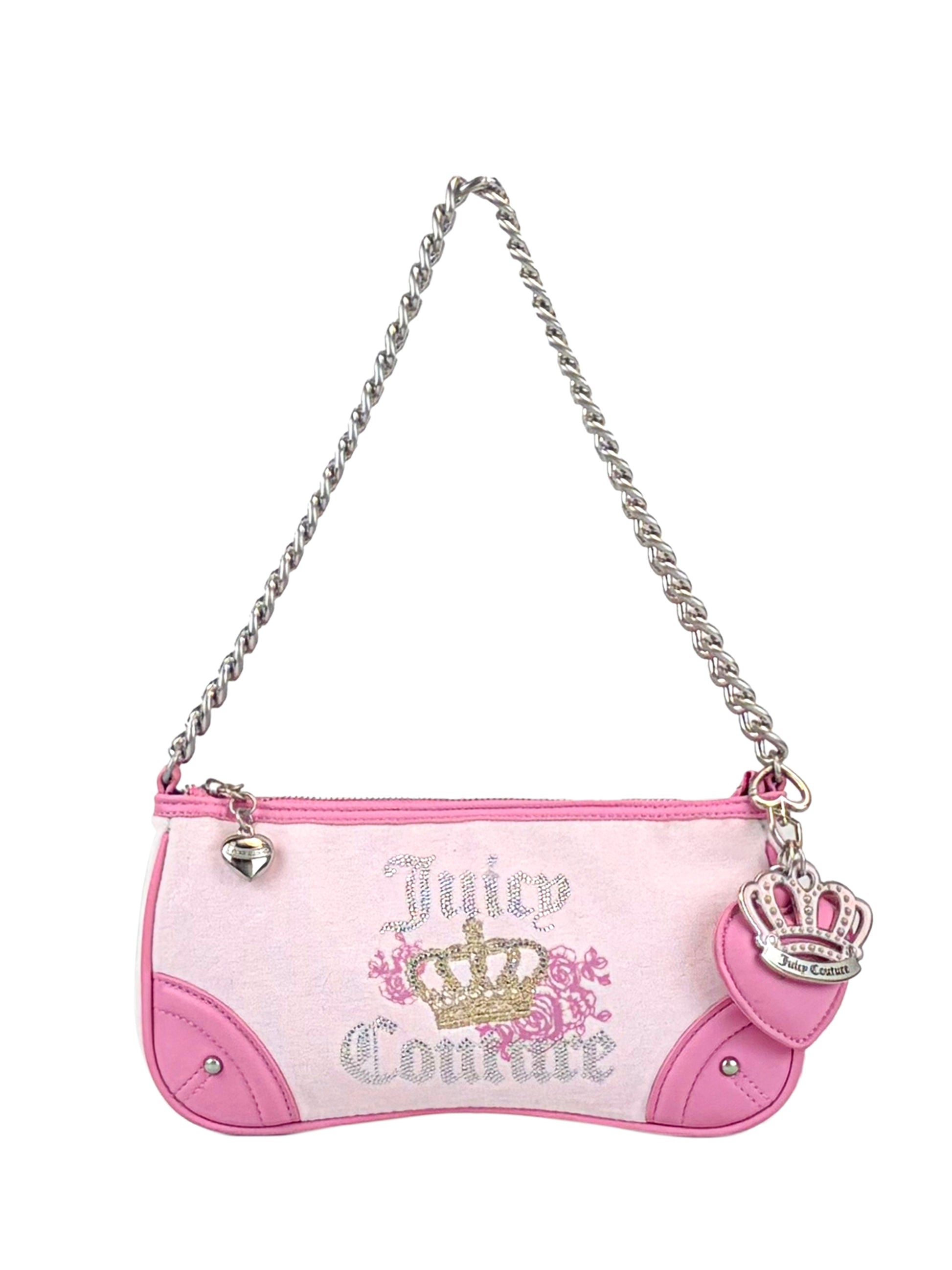 The Royal Bloom Shoulder Bag by Juicy Couture is a small pink and white bag featuring a sleek silhouette, silver chain strap, heart zipper pull, pink crown charm, gold crown and floral design, plus Juicy Couture text on the front.
