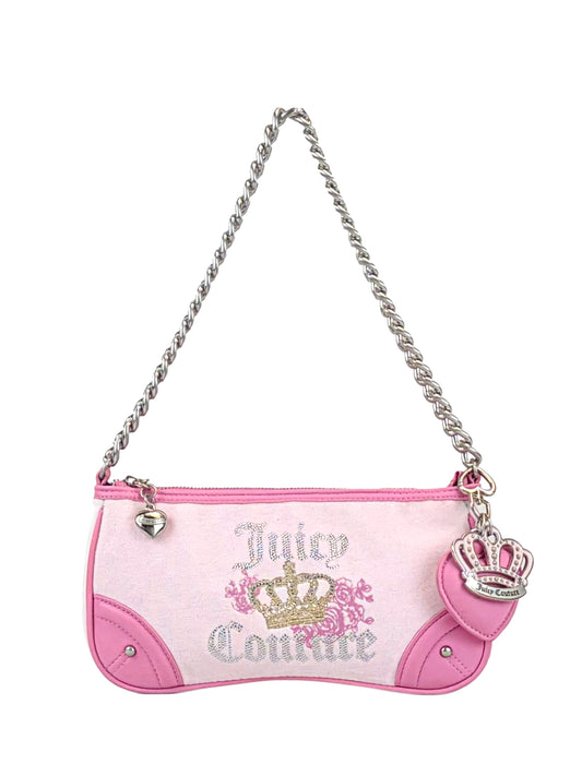 The Royal Bloom Shoulder Bag by Juicy Couture is a small pink and white bag featuring a sleek silhouette, silver chain strap, heart zipper pull, pink crown charm, gold crown and floral design, plus Juicy Couture text on the front.
