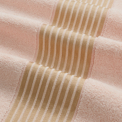 A close-up of the Melissa Bath Towel Set, showcasing soft 100% cotton towels with wide peach and narrow beige stripes, featuring raised ribbed lines on the beige bands for added texture and comfort.