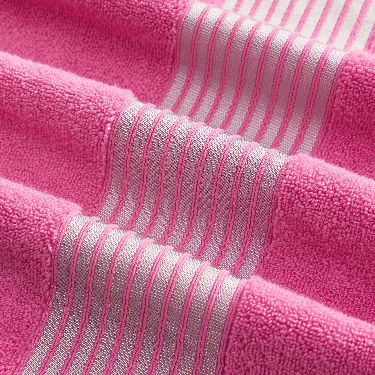 A close-up of the Melissa Bath Towel Set in pink, showcasing textured zero-twist 100% cotton towels with lighter pink and white horizontal stripes for a soft, stylish look.