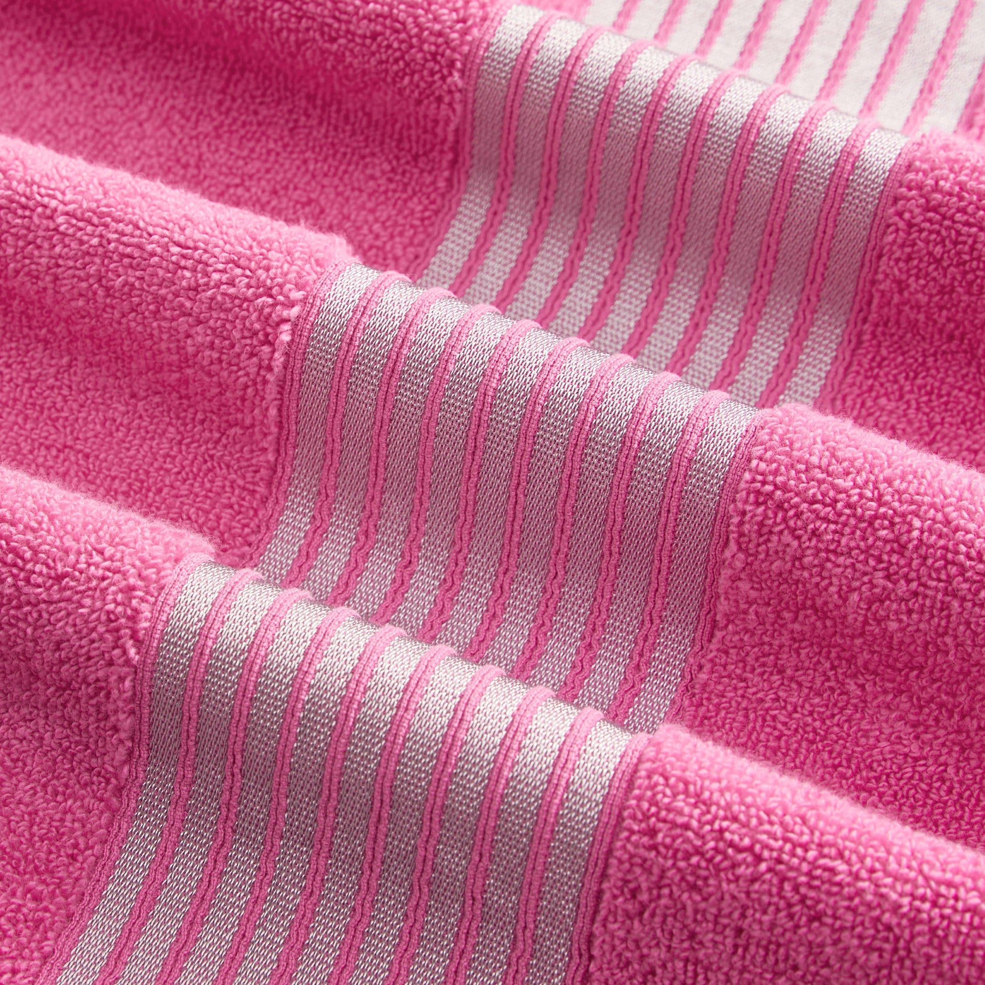 A close-up of the Melissa Bath Towel Set in pink, showcasing textured zero-twist 100% cotton towels with lighter pink and white horizontal stripes for a soft, stylish look.