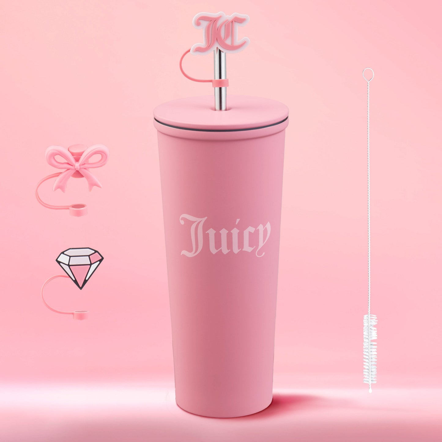 The Couture Hydration Stainless Steel Tumbler Cup 6-Piece Set is a tall, matte pink Juicy Couture cup with “Juicy,” a pink straw and JC charm, plus a bow-shaped straw topper, diamond charm, and cleaning brush on a pink background.