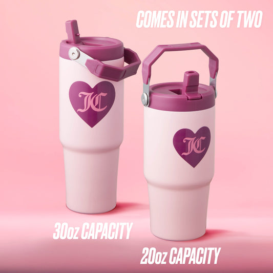 The Flip Flow Hydration Stainless Steel Tumbler Cup 2-Pack features two pink travel mugs with purple hearts and handles, set against a pink background. The insulated gift set includes 30oz and 20oz tumblers, ideal for stylish travel.