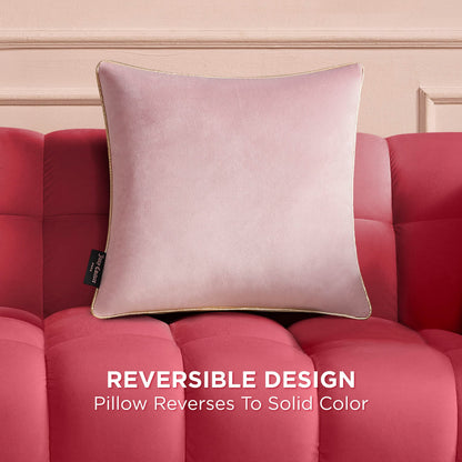 A Velvet Cheetah Pillow with gold trim rests on a red tufted sofa, set against a light pink wall. Text below reads, REVERSIBLE DESIGN – pillow reverses to solid color.