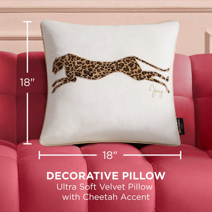 A white 18x18 Velvet Cheetah Pillow with a gold cheetah accent sits on a pink tufted sofa. The image text highlights this decorative pillow’s velvet texture, chic design, and exact dimensions.