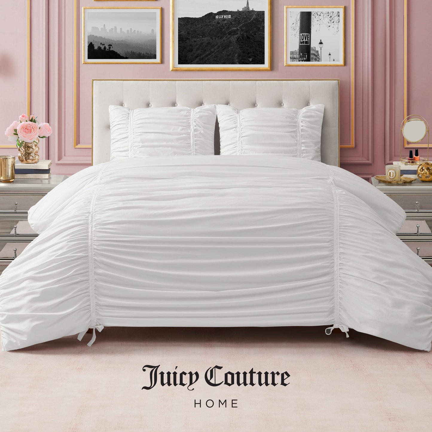 A stylish bedroom features a neatly made bed with the Ribbon Ruched Comforter Set and pillows, pink walls, gold-framed black-and-white photos, elegant bedside tables, and "Juicy Couture Home" at the bottom.