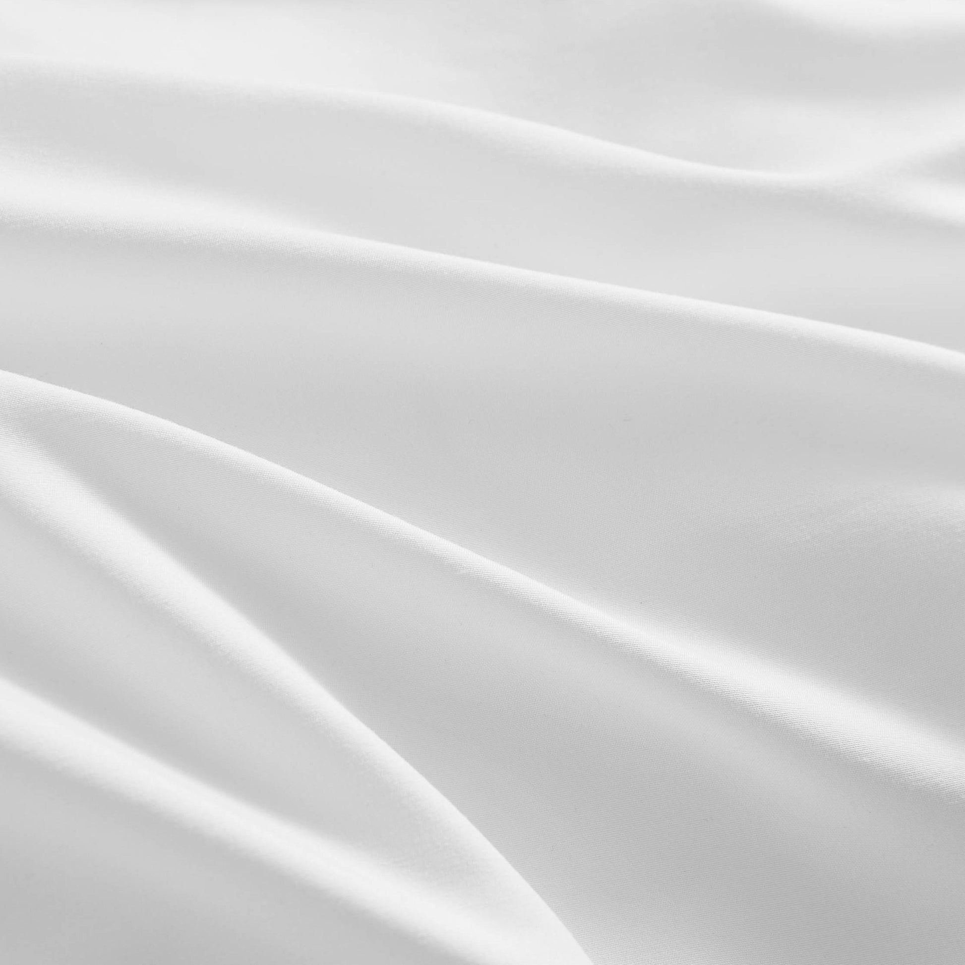Close-up of the Ribbon Ruched Comforter Set, featuring white, smooth fabric with gentle folds and curves that create a calm and elegant texture.