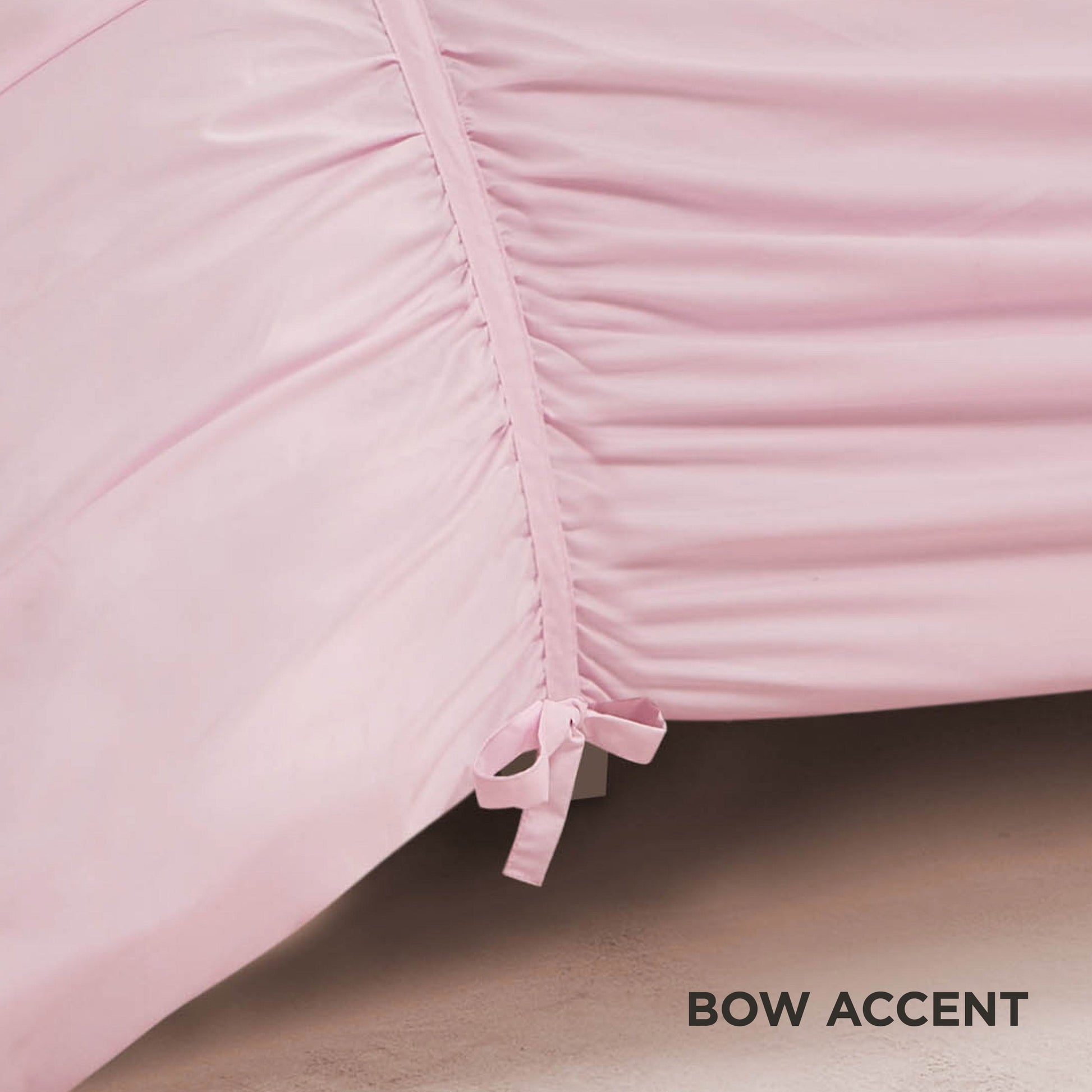 A close-up of the Ribbon Ruched Comforter Set in light pink highlights its ruched seams and a small matching bow, with elegant ribbon detailing. The words BOW ACCENT appear in black text at the bottom right.