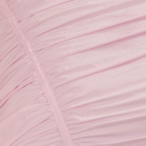 Close-up of the Ribbon Ruched Comforter Set fabric shows light pink material with gathered, pleated lines running diagonally for a textured, slightly shiny surface.