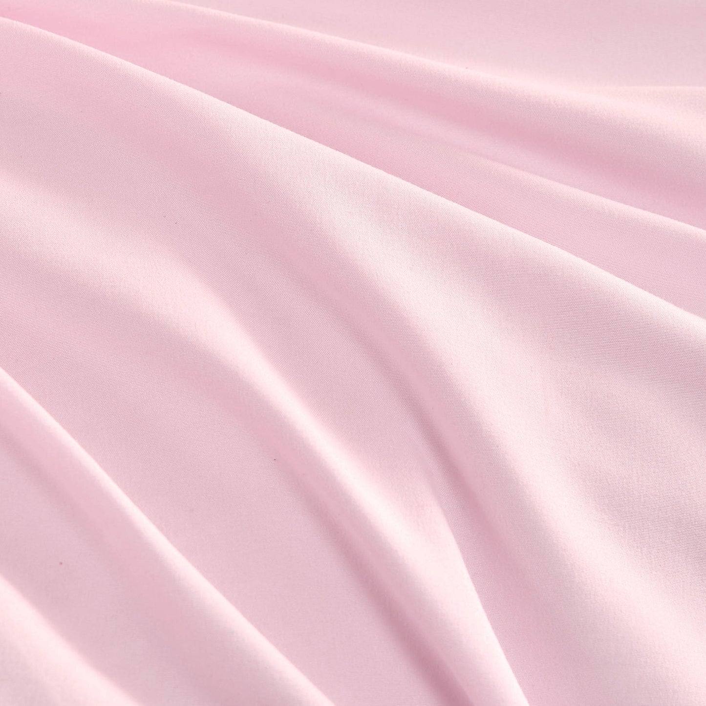 The Ribbon Ruched Comforter Set features soft pink fabric with gentle folds and a smooth texture, creating subtle shadows and highlights that evoke the luxurious feel of a Juicy Couture comforter set.