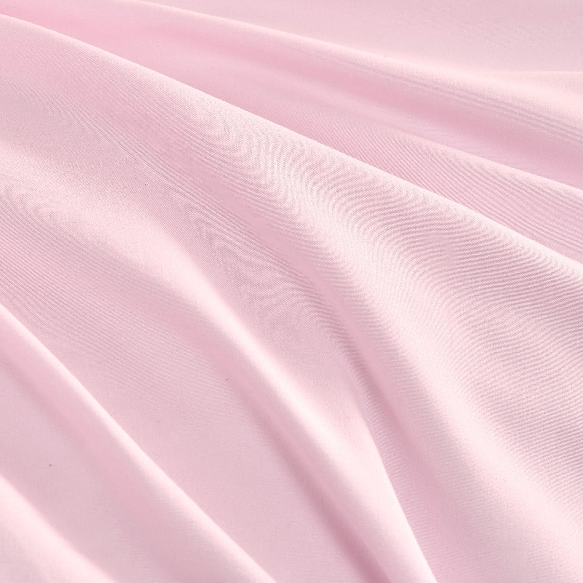 The Ribbon Ruched Comforter Set features soft pink fabric with gentle folds and a smooth texture, creating subtle shadows and highlights that evoke the luxurious feel of a Juicy Couture comforter set.