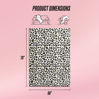 A Plush Throw Blanket with a black and gold heart and leopard print pattern is displayed on a pink background. Text reads Product Dimensions: 70" x 50". Sofa and person icons appear above.