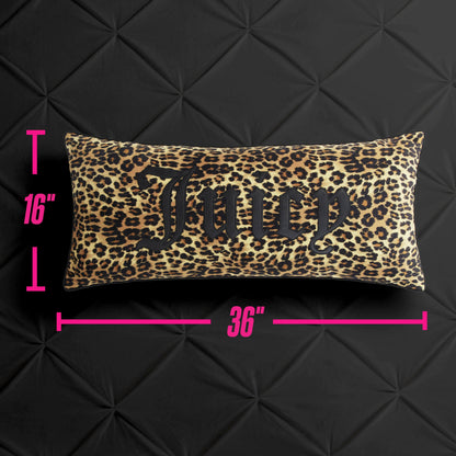 The Gothic Cheetah Decorative Pillow is a rectangular accent pillow showcasing a striking cheetah print with the word "Juicy" in bold black lettering. Pink measurement lines display its dimensions—16 inches tall by 36 inches wide—against a quilted black backdrop.