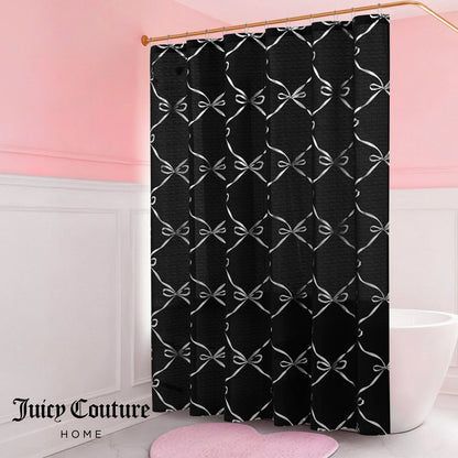 A bathroom with pink and white walls, a white tub, a bow-patterned Shower Curtain and Hooks Set, a pink heart-shaped rug, and the Juicy Couture Home logo in the lower left—perfect for chic bathroom decor.
