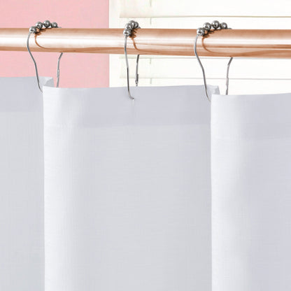 Close-up of the Shower Curtain and Hooks Set hanging from a light wooden rod with silver hooks, featuring ball bearings, against a pink wall and white blinds for a chic, modern look.