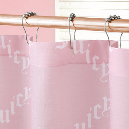 A close-up of the Shower Curtain and Hooks Set in light pink fabric with "Juicy" in white gothic lettering, hanging on a metal rod with round hooks. A white window blind and pink wall add to the chic bathroom decor.