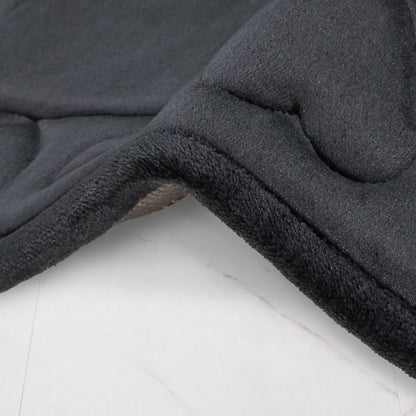 A close-up of a dark gray Quilted Memory Foam Bath Mat from a 2-piece set, draped over a light surface, highlighting its plush, soft texture and curved edge.