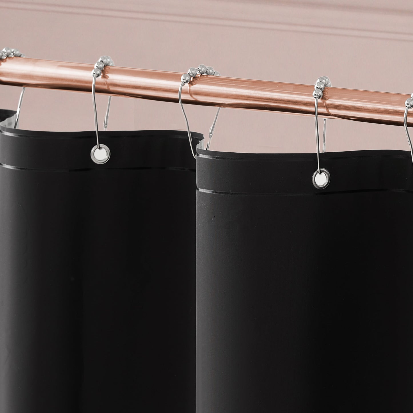 Close-up of the Sweet Bow Shower Curtain with PEVA Liner and Hooks 14-Piece Set in black, displayed on a copper shower rod with silver hooks against a light pink wall—perfect for elevating your bathroom decor.