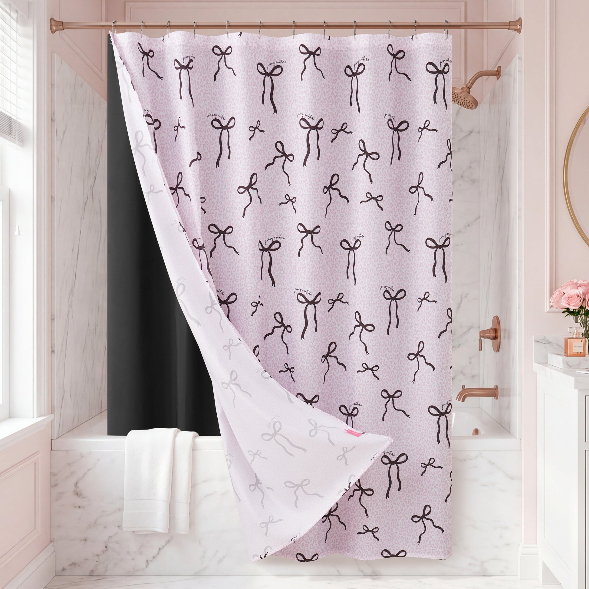 A pink bathroom with marble walls and a bathtub is accented by the Bow Leopard Shower Curtain, which features a chic pattern of black bows. White towels hang nearby, adding elegance to the decor, while pink flowers sit on the sink.