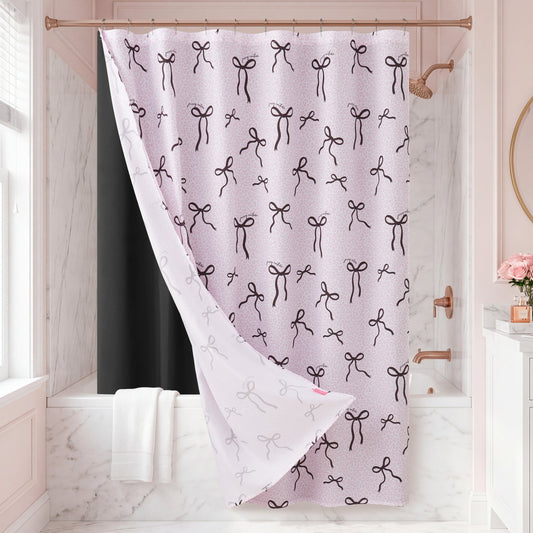 A pink bathroom with marble walls and a bathtub is accented by the Bow Leopard Shower Curtain, which features a chic pattern of black bows. White towels hang nearby, adding elegance to the decor, while pink flowers sit on the sink.