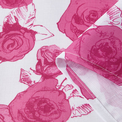 A close-up of the Larissa Floral Shower Curtain with PEVA Liner and Hooks 14-Piece Set displays its white fabric adorned with pink rose patterns, featuring a folded corner to showcase the textured material and vibrant floral print—an ideal choice for bringing a fresh, elegant touch to your bathroom decor.