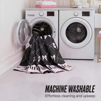 A black and pink patterned Shower Curtain and Hooks Set is partially inside an open front-loading washing machine in a laundry room. Text reads: Machine Washable—Effortless to clean, great for matching your bathroom decor.